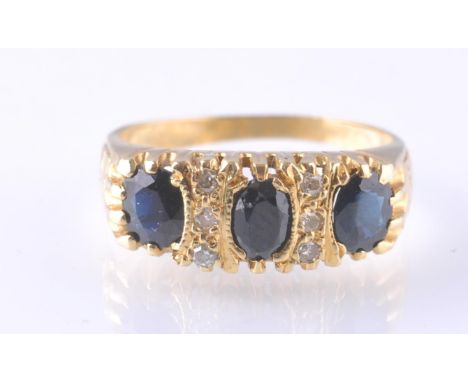 An 18ct gold sapphire and diamond ring. The oval cut sapphires surrounding inset 6 low point diamonds. Sapphires approx 4mm x