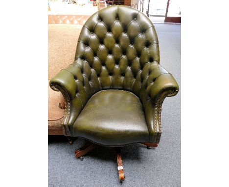 A leather button back swivel armchair