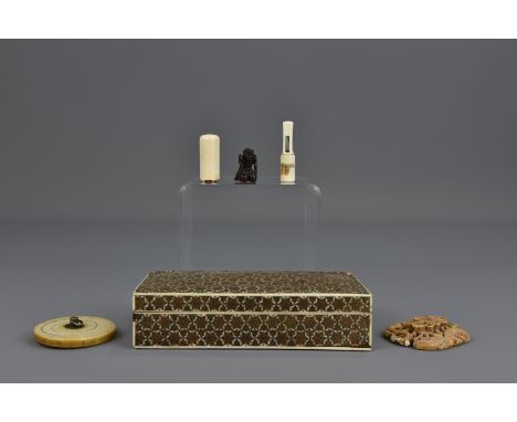 Two Japanese ivory seals, an 18th century Chinese ivory carving, a Japanese ivory cover and a small carved wooden figure in a