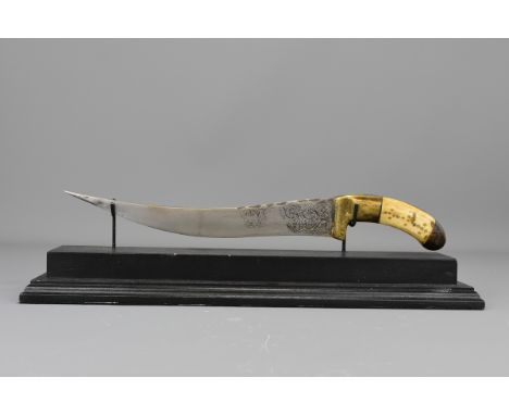 A Middle-Eastern sword with bone handle on display stand. 37 cm length.