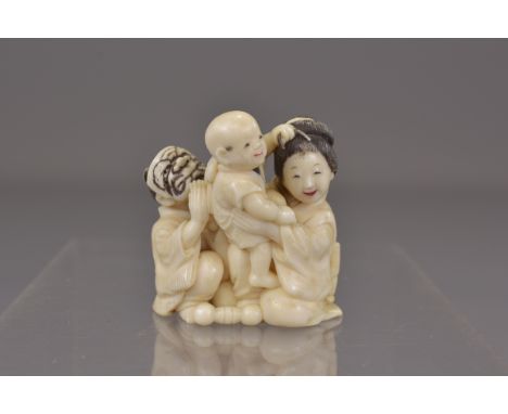 A Japanese Meiji period carved ivory netsuke of family and child. 4cm x 4cm 