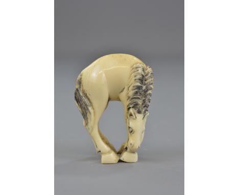 A Japanese carved ivory netsuke in the form of a horse. Signed to back. 5cm tall 