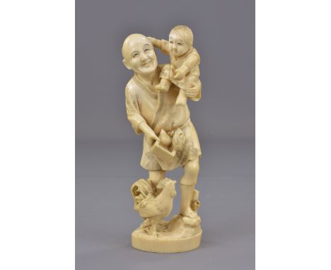 A Japanese Meiji period carved ivory Okimono of a famer and boy feeding chickens. Signed. 18 cm tall 