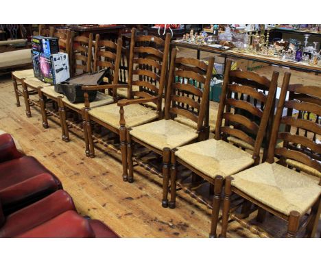 Set of eight Country style ladder back rush seated dining chairs comprising one carver and seven single