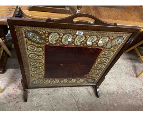 A large wooden fire screen inset with glazed decorative silk and velvet embroidery