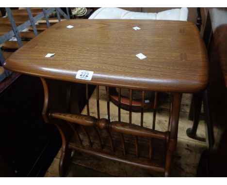 An Ercol dark elm magazine rack with stick dividers, set on pierced standard ends