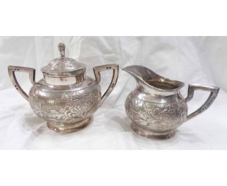 A Chinese export white metal two handled and lidded sucrier and matching cream jug of European design, with embossed floral a