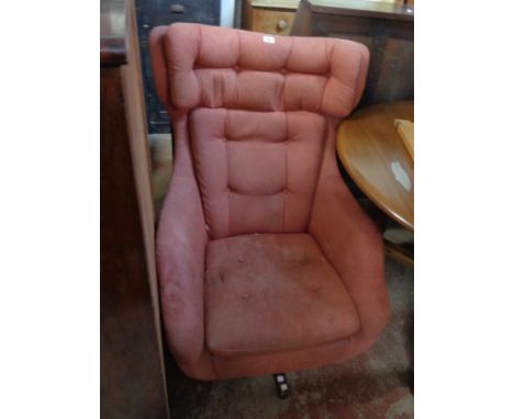 A vintage Parker Knoll 'Statesman' armchair chair with original dusky pink button back upholstery, set on a swivel five star 