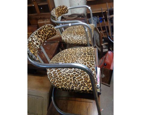 A pair of retro tubular metal framed chairs with leopard print upholstery