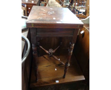A 48cm Edwardian stained walnut envelope card table with blue baise lined interior, set on turned supports with uniting centr