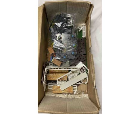 A box containing vintage toy farm pieces and accessories