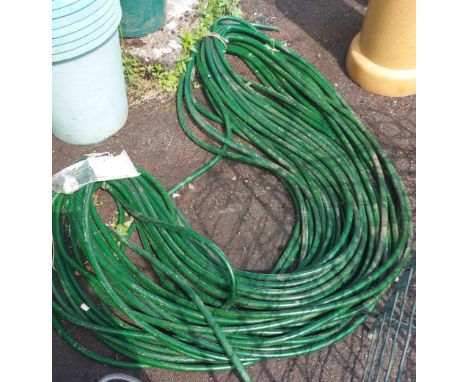 A green reinforced hose pipe - approximately 95m long