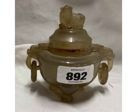 An antique Chinese carved agate tripodal censer decorated with dragon mask loops either side and a temple lion finial