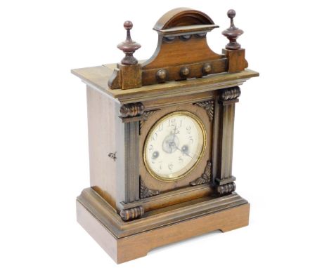 A late 19thC walnut cased mantel clock, with carved pillar cornice, on two column supports, on a stepped and shaped base, 38c