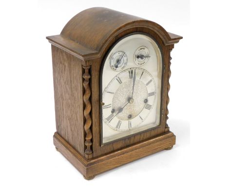 An oak cased mantel clock, with silvered colour dial with chime and silent movement, with barley twist columns, 35cm high, 26