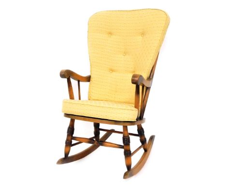 An Ercol style rocking chair, with yellow upholstered cushions, light elm, 102cm high, 53cm wide, 55cm deep.  The upholstery 