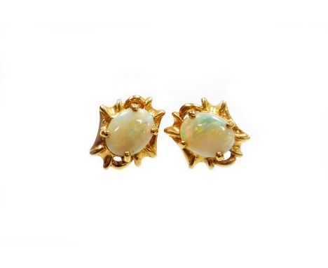 A pair of opal stud earrings, with oval opal in four claw setting, surrounded by abstract twist design bordering, on stem bac