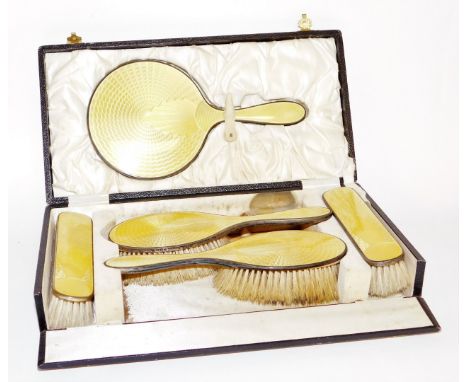 A silver and yellow enamelled dressing table set, with hand brushes, mirror and side brushes, in a fitted case, Birmingham. 