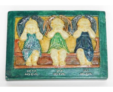 A Compton pottery plaque of three cherubs, hear no evil, say no evil, see no evil, with Compton pottery stamp to reverse, 15c