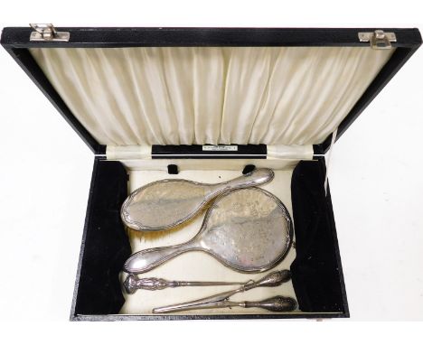 A George VI silver cased dressing table set, comprising hand brush, hand mirror, and glove stretchers, the mirror and brush e