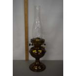 A metal oil lamp with glass chimney