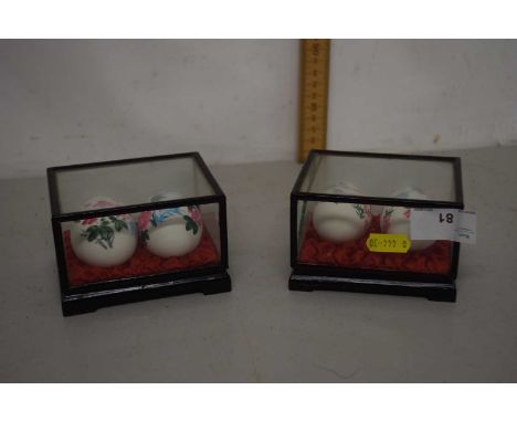 Two cased ceramic eggs painted in Asian style