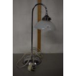 A chrome desk lamp with frosted glass shade