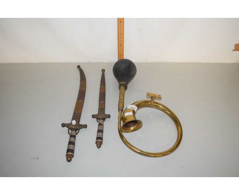 A brass model of a vintage car horn together with two Middle Easter knives