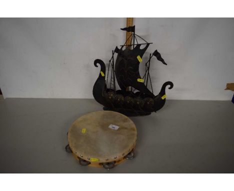 A vintage tamborine with metal model of a Viking boat