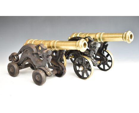 Two model brass cannon with dragon decoration to the four wheeled carriages, length of longer 48cm
