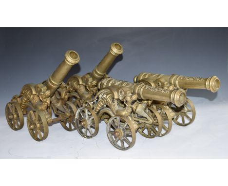 Set of four model brass cannon with dragon decoration to the four wheeled carriages, overall length 42cm