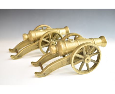 Pair of model cannon of brass construction, the star to top of barrels, overall length 34cm