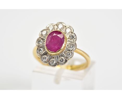 AN 18CT GOLD CLUSTER RING, set with a central oval ruby with a round brilliant cut diamond surround, to the tapered shoulders