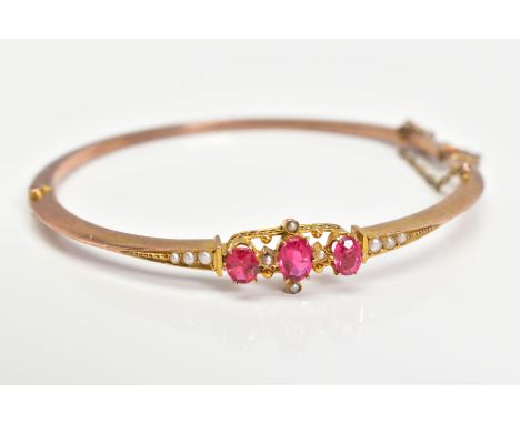 AN EARLY 20TH CENTURY GOLD SPLIT PEARL AND GARNET TOPPED DOUBLET FANCY BANGLE, measuring approximately 65mm x 60mm, approxima