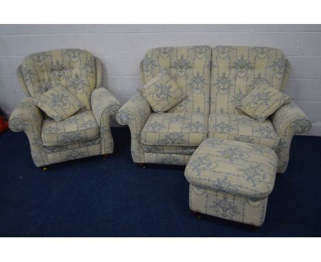 A FOLIATE BLUE AND CREAM UPHOLSTERED THREE PIECE LOUNGE SUITE, comprising a two seater settee, an armchair and pouffe (3)