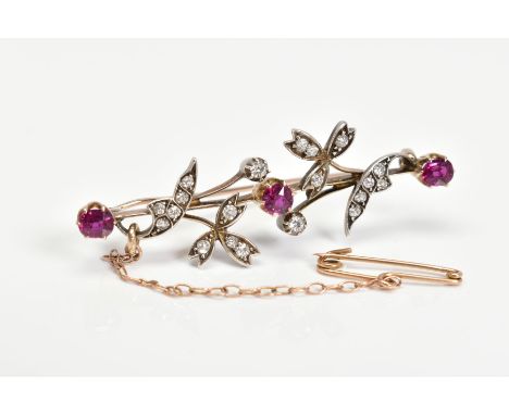 A GOLD EARLY 20TH CENTURY RUBY AND DIAMOND FLORAL BAR BROOCH, three oval and round cut rubies measuring approximately 4.6mm x