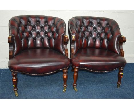 A PAIR OF MODERN OXBLOOD LEATHER BUTTON BACK ARMCHAIRS on brassed casters, width 67cm x depth 71cm x height 78cm