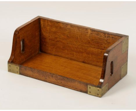 AN OAK AND BRASS BOOK CARRIER OR SHELF, with a cut carrying handle each side, 19th century, 57cm wide. Provenance: Peter Bron