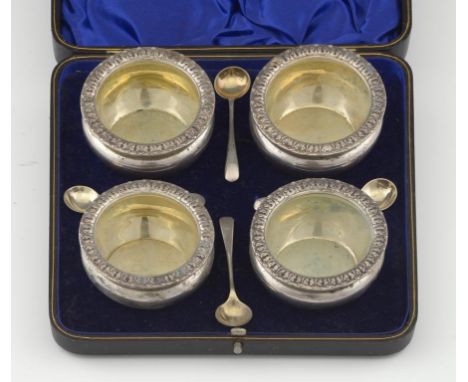 A SET OF FOUR VICTORIAN SILVER SALT CELLARS with waterleaf rim and four spoons, salts 7cm diam, by W Hutton & Sons Ltd, Londo