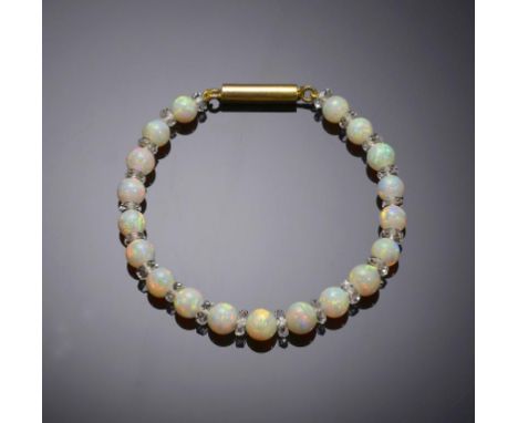 A BRACELET OF OPAL BEADS with clear faceted bead spacers, gold clasp, 18cm l, indistinctly marked on tongue and barrel, 9g ++