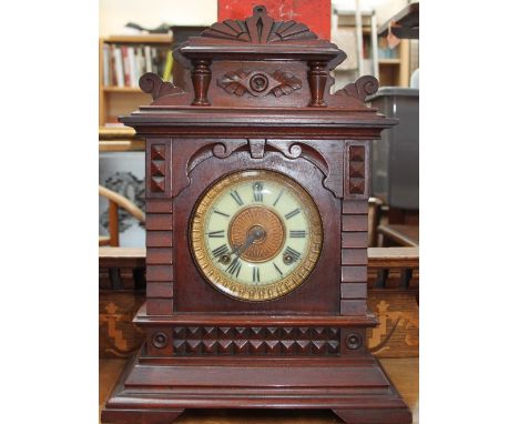 An early 20th century mantle clock with a circular dial and Roman numerals