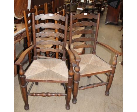 A set of eight 20th century oak ladder back dining chairs, with rush seats, includes two carvers