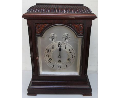 An early 20th century mahogany bracket clock, with a domed top, the silvered dial with Arabic numerals and two subsidiary dia