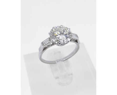 the central stone measuring 3.1cts approx., having flanking diamond baguette cut shoulders, ring size O, 4.5gmsProvenance: pr