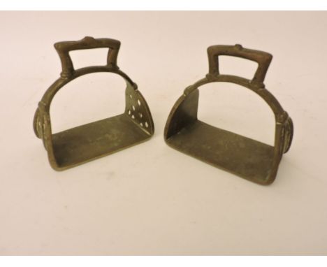 A pair of Tibetan brass stirrups, probably 19th century, a pair of late nineteenth century tall brass ejector candlesticks, p