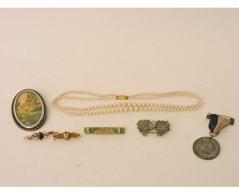 A gold Jade Kia-ora brooch, marked 9ct, a 9ct gold garnet and split pearl bar brooch, a Victorian bar brooch set with a diamo