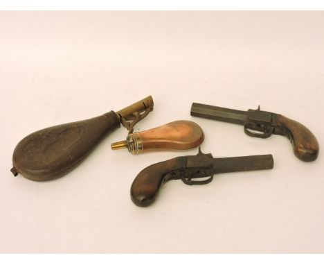 A pair of early 19th century percussion muff pistols, a copper powder flask and a leather powder flask