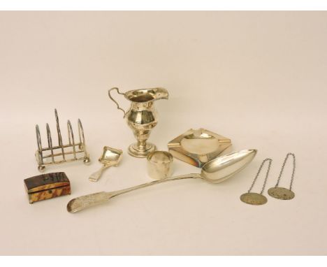 A George III basting spoon, William Welch II, Exeter 1813, further silver items comprising a toast rack, caddy spoon, ashtray