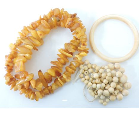 A single row of graduated Victorian ivory bead necklace, a Victorian ivory bangle, and a single row of graduated freeform amb