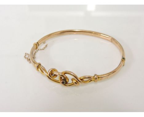 A gold hollow hinge bangle, with twisted knot centrepiece, 5.56g, damaged